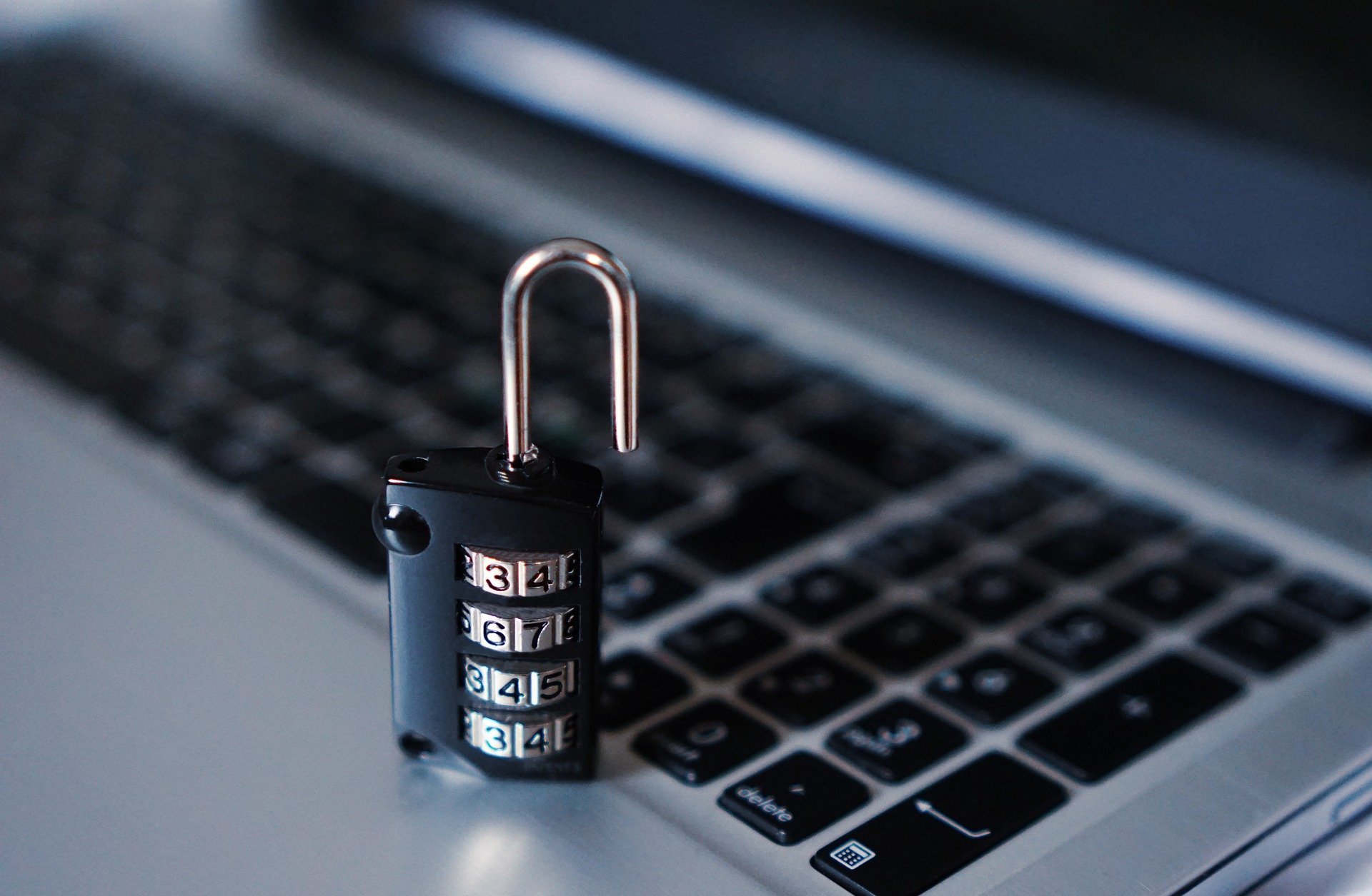 Ein Kombinationsverschluss auf einer Laptop-Tastatur symbolisiert Zutrittskontrolle und Sicherheitstechnik, zentrale Leistungen von Limburger Sicherheitstechnik.