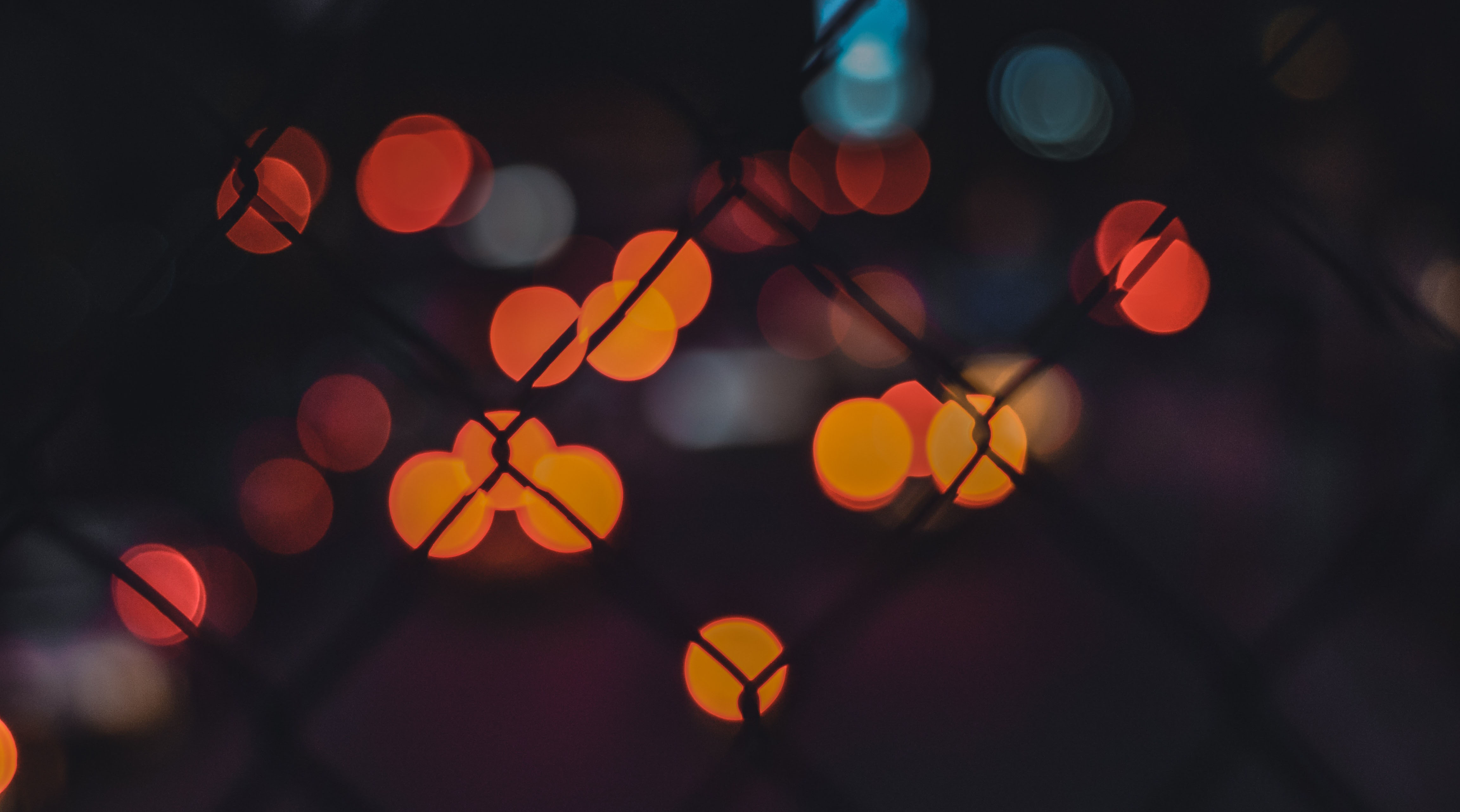 Abstrakte Bokeh-Lichteffekte in Rot, Orange und Blau auf dunklem Hintergrund, die die moderne Sicherheitstechnik von Limburger Sicherheitstechnik symbolisieren – von Einbruch- und Brandmeldesystemen bis zur Videoüberwachung.