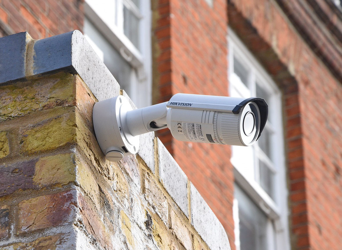 Hikvision Überwachungskamera an einer Ziegelmauer, montiert als Teil einer professionellen Videoueberwachungsanlage für Sicherheitslösungen.
